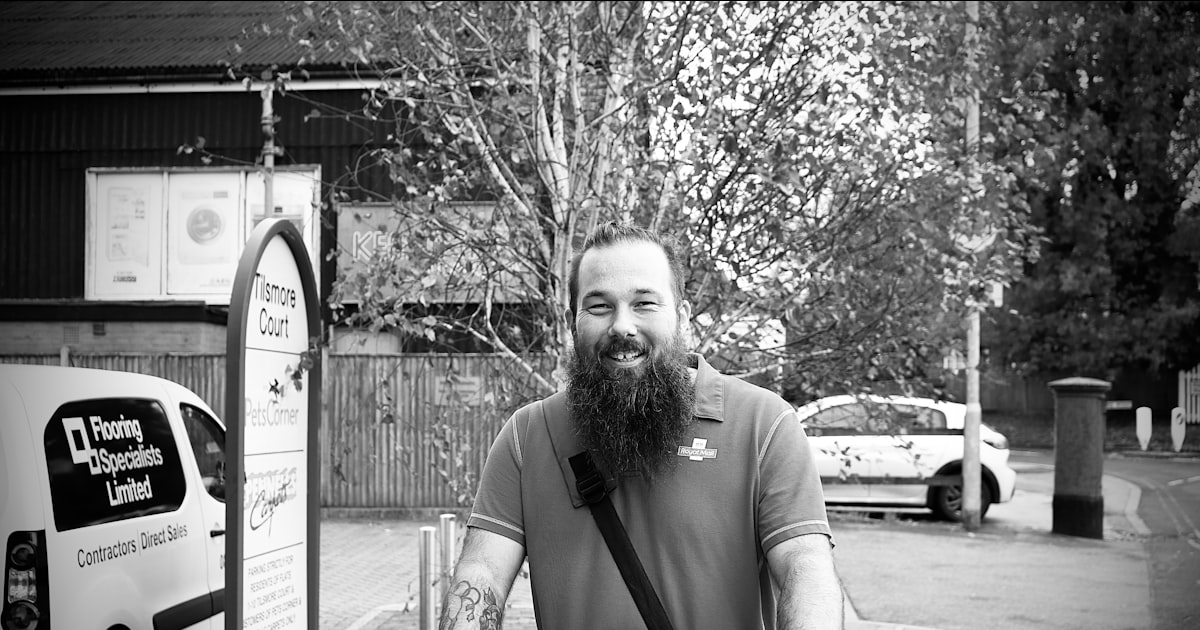 Man with beard and tattoos pushing a bicycle