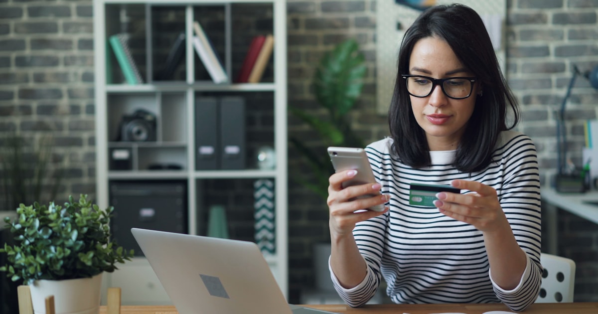 A woman sitting at a table looking at her cell phone