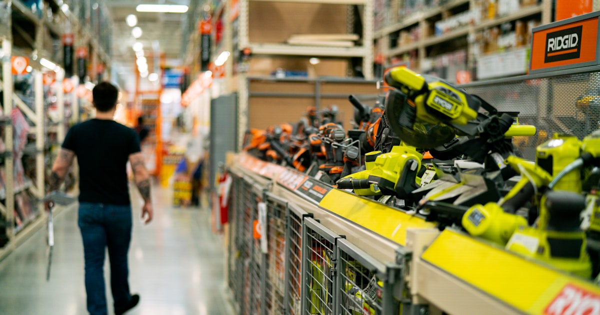 A man is walking down a store aisle