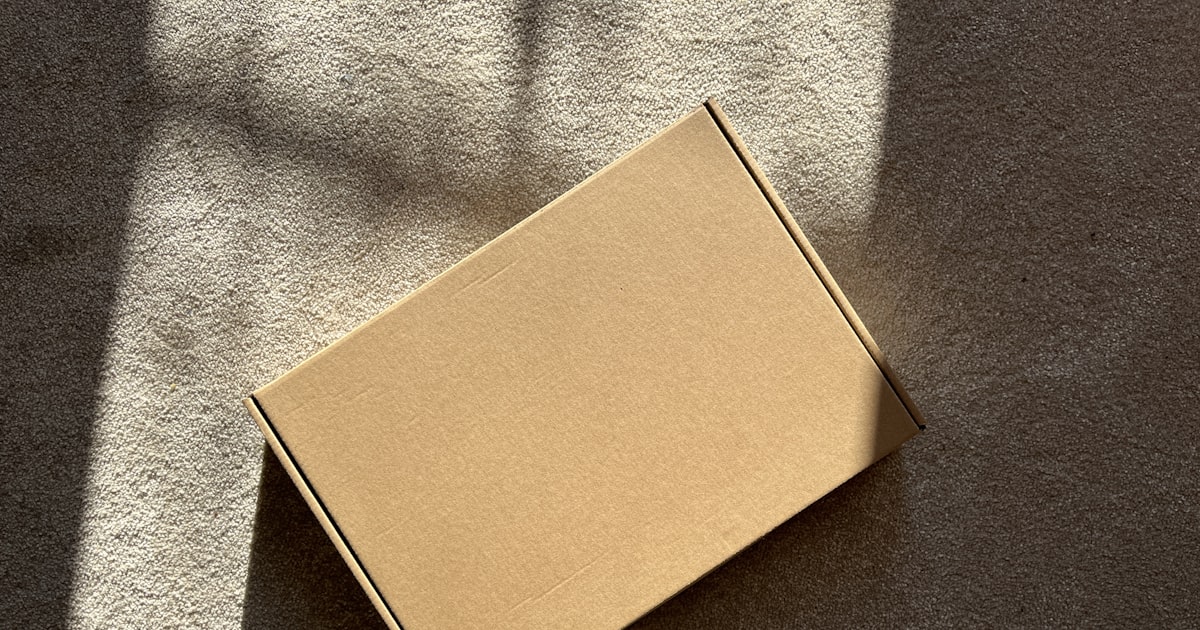 A cardboard box sits on a textured surface.