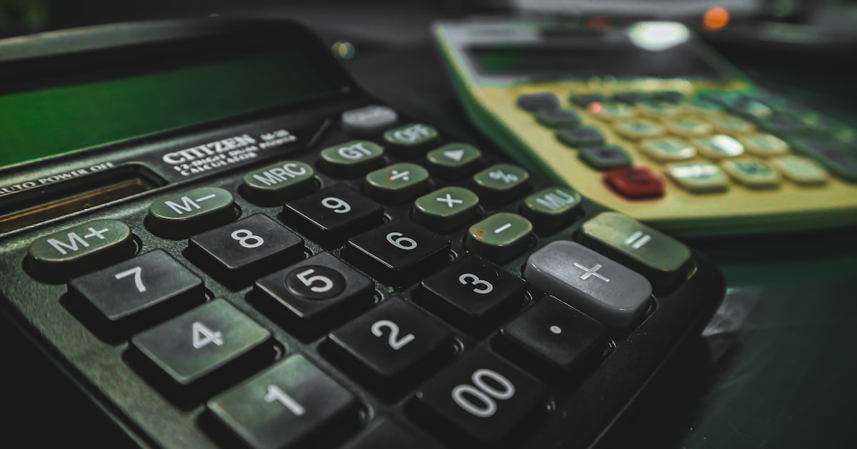 A calculator sitting on top of a table next to another calculator