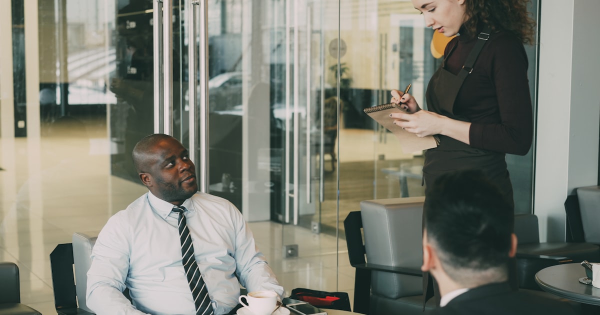 Business meeting with waiter taking notes