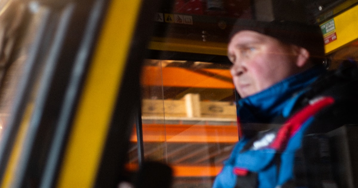 A man sitting in a yellow bus with his head out of the window