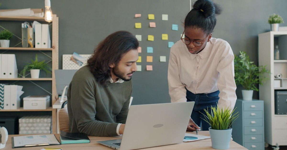 Two colleagues collaborating on a project at a desk