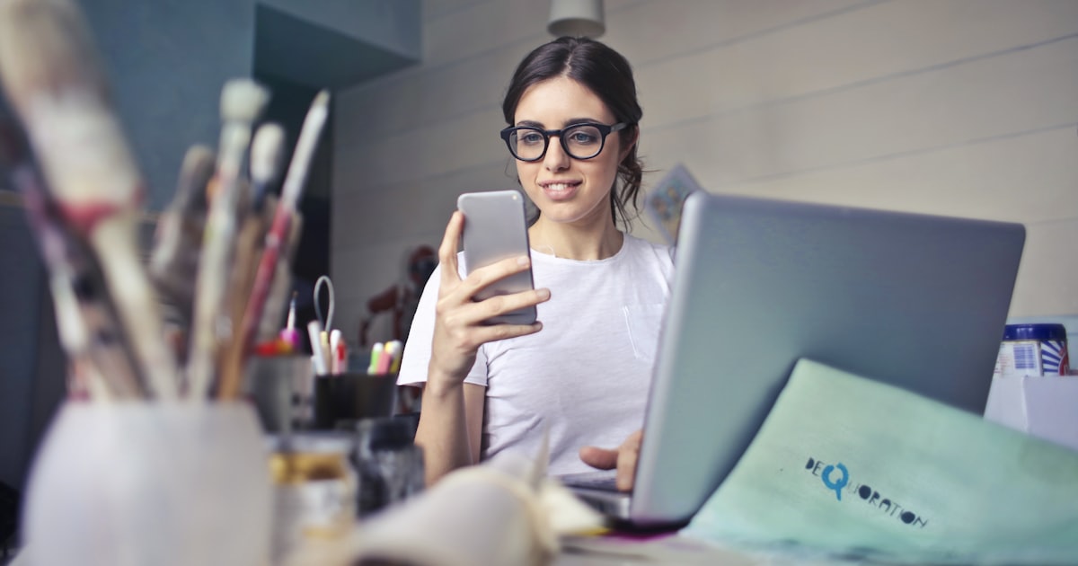 woman in white shirt using smartphone