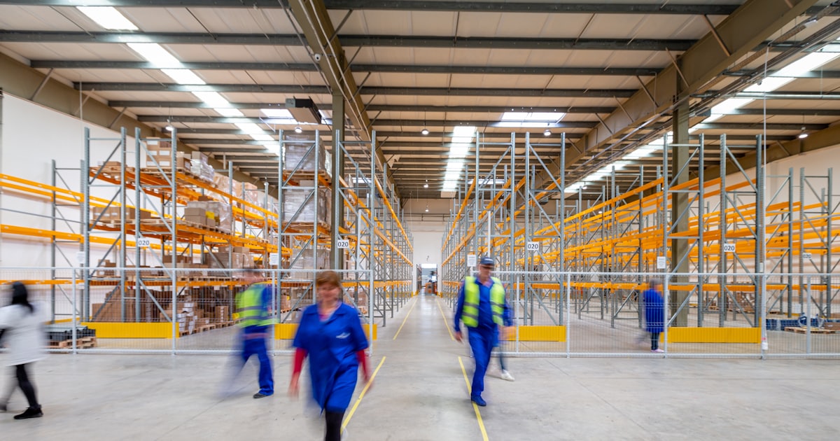 workers walking through warehouse aisle