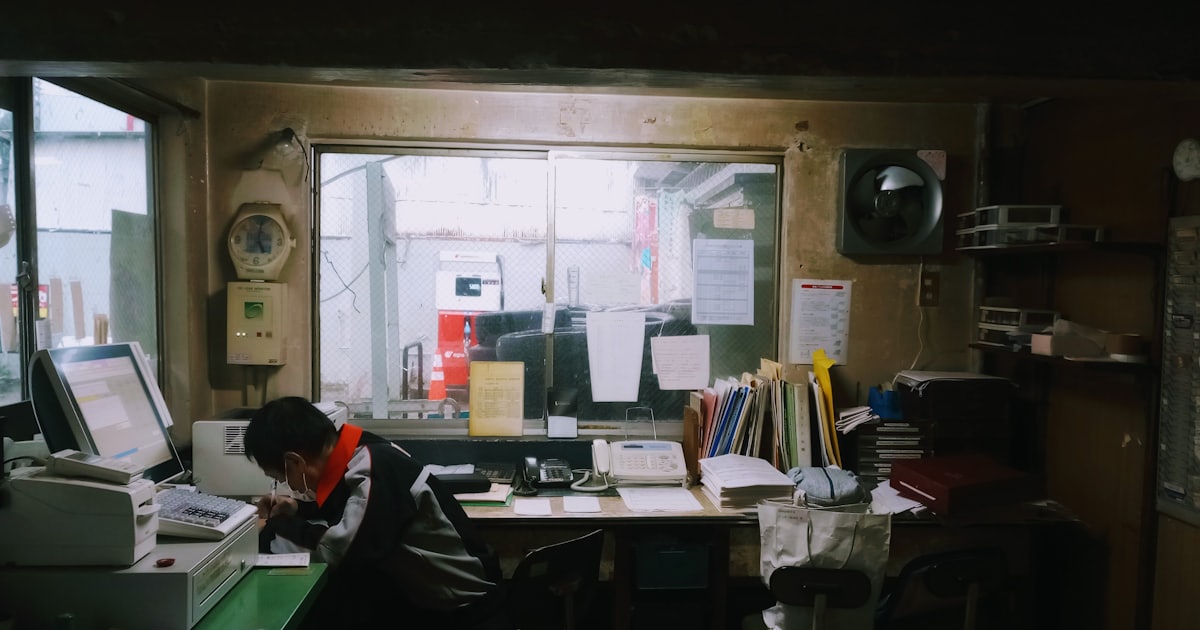 Man working at a cluttered desk with a computer