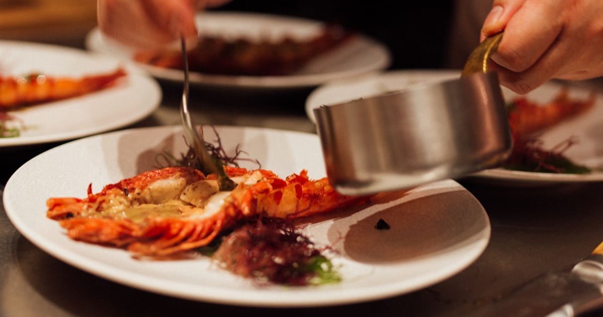 a person in a chefs uniform preparing food on a table