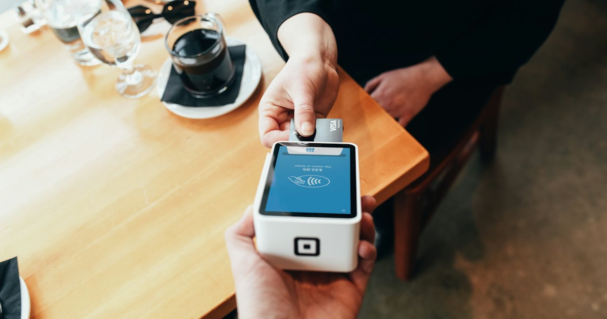 person holding credit card swipe machine