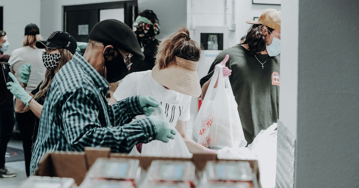 people standing in front of brown cardboard boxes