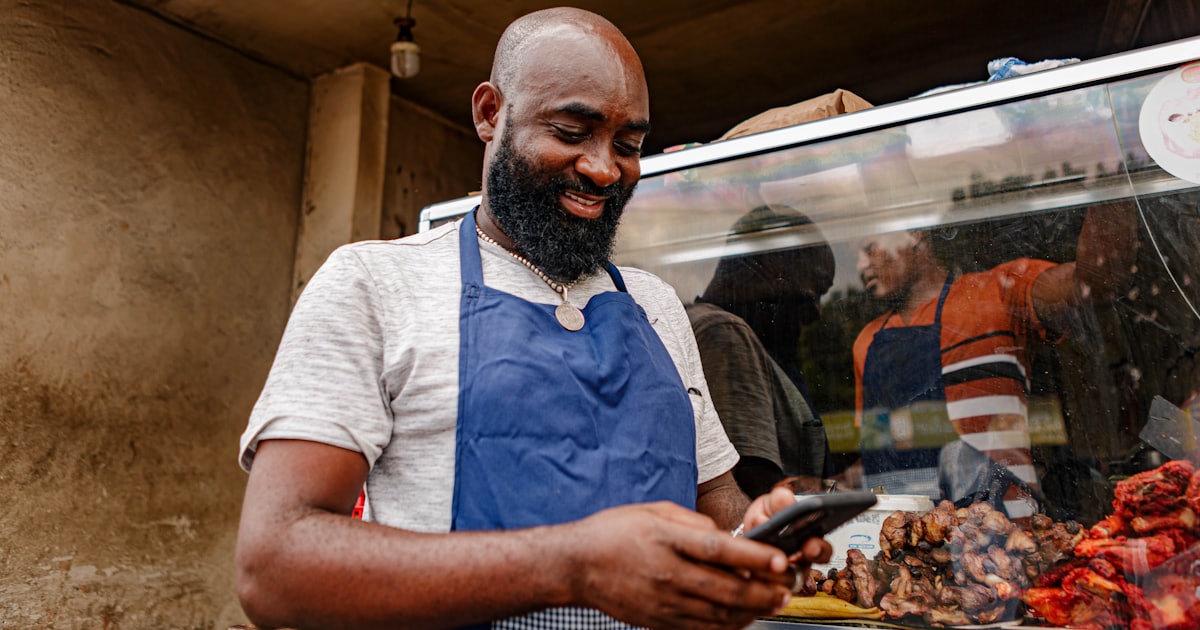 a man in an apron looking at a phone