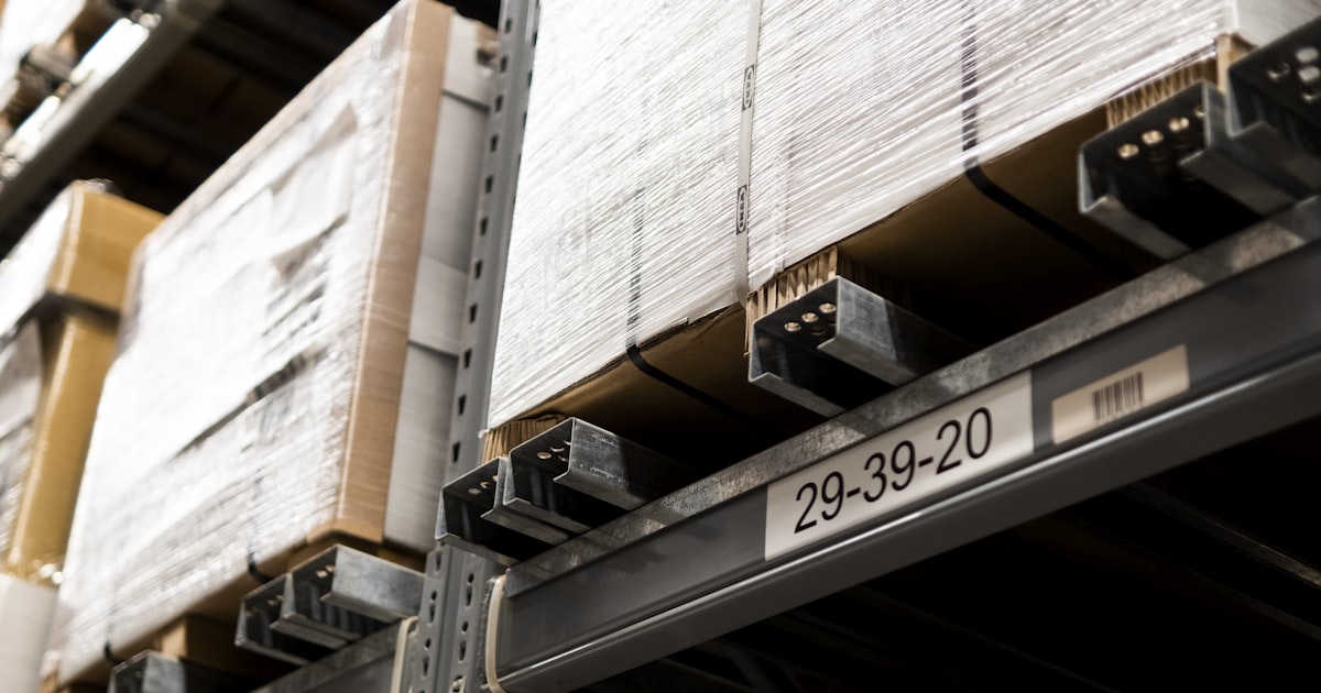 A close up of a metal shelf with boxes on it