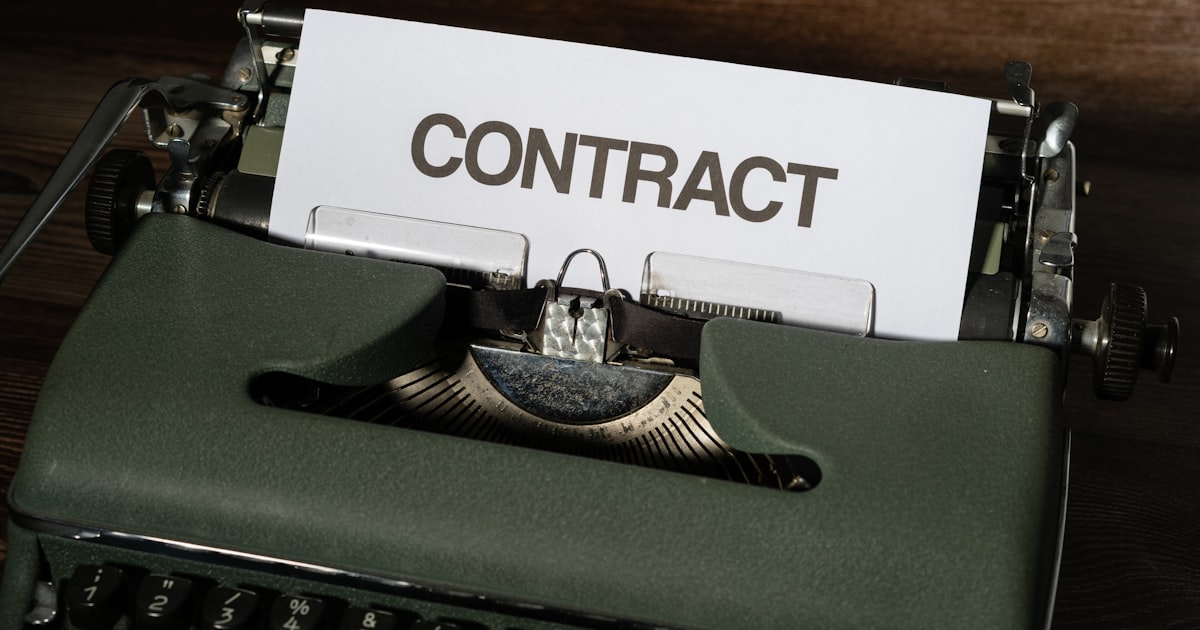 A close up of a typewriter with a sign that reads contact