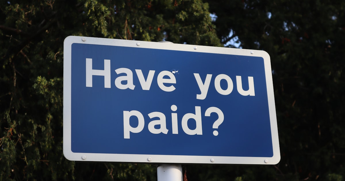 A blue sign that says have you paid?