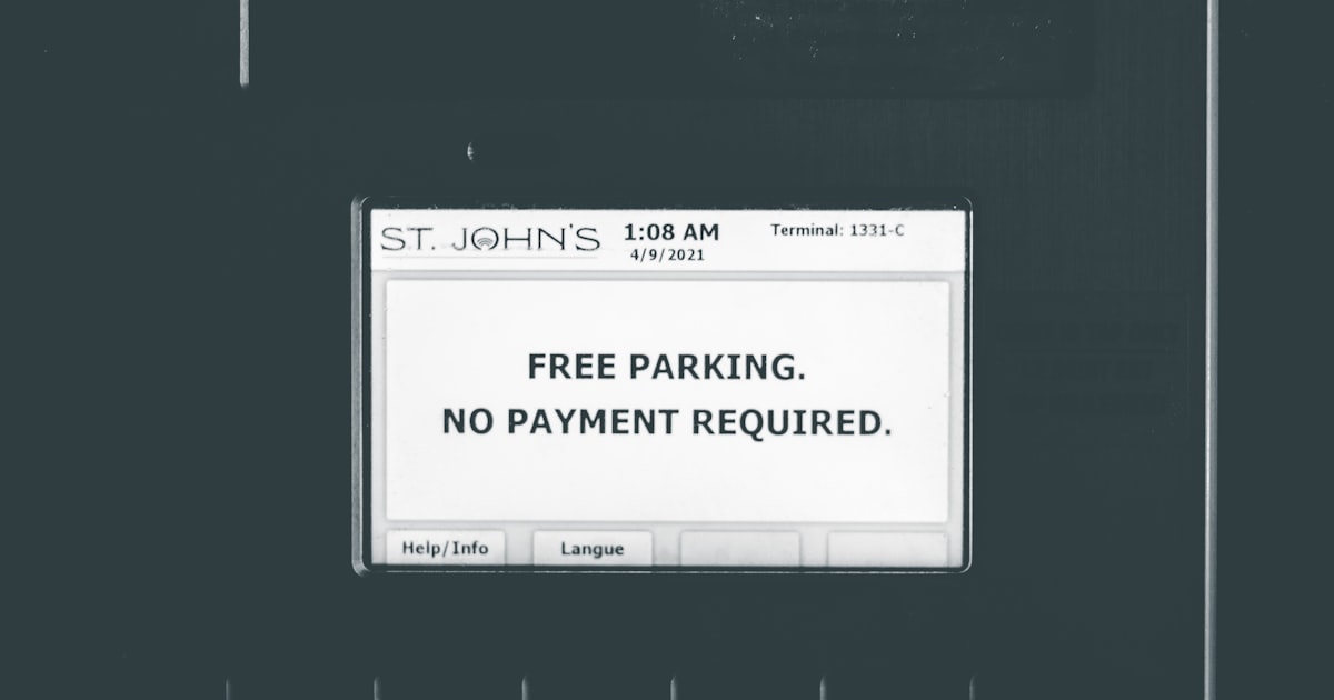 A black and white photo of a parking sign