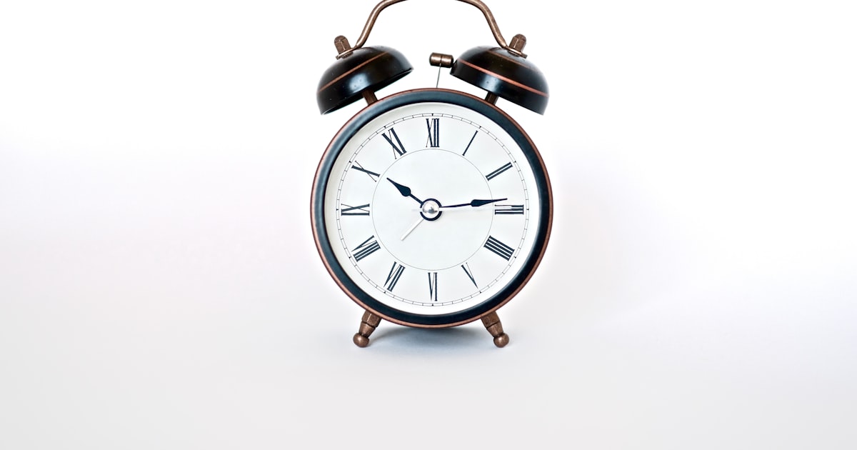 Round black and white analog alarm clock