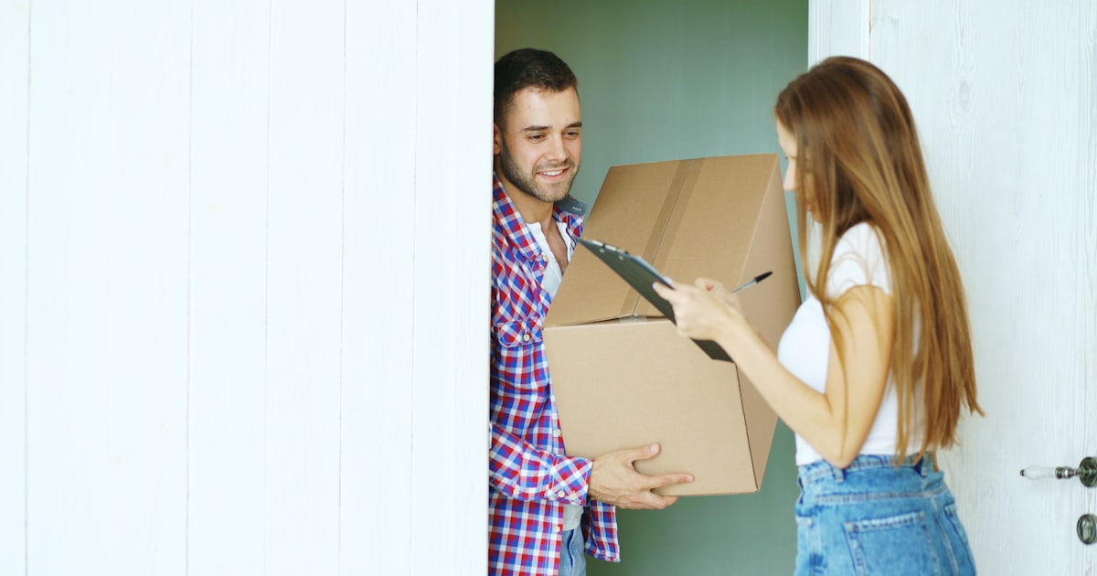 Couple signing for a package delivery at the door
