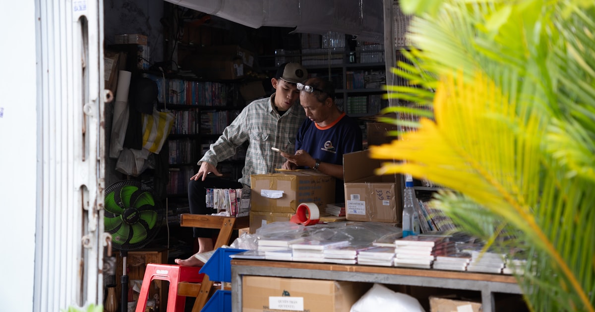 Two people working in a cluttered store.