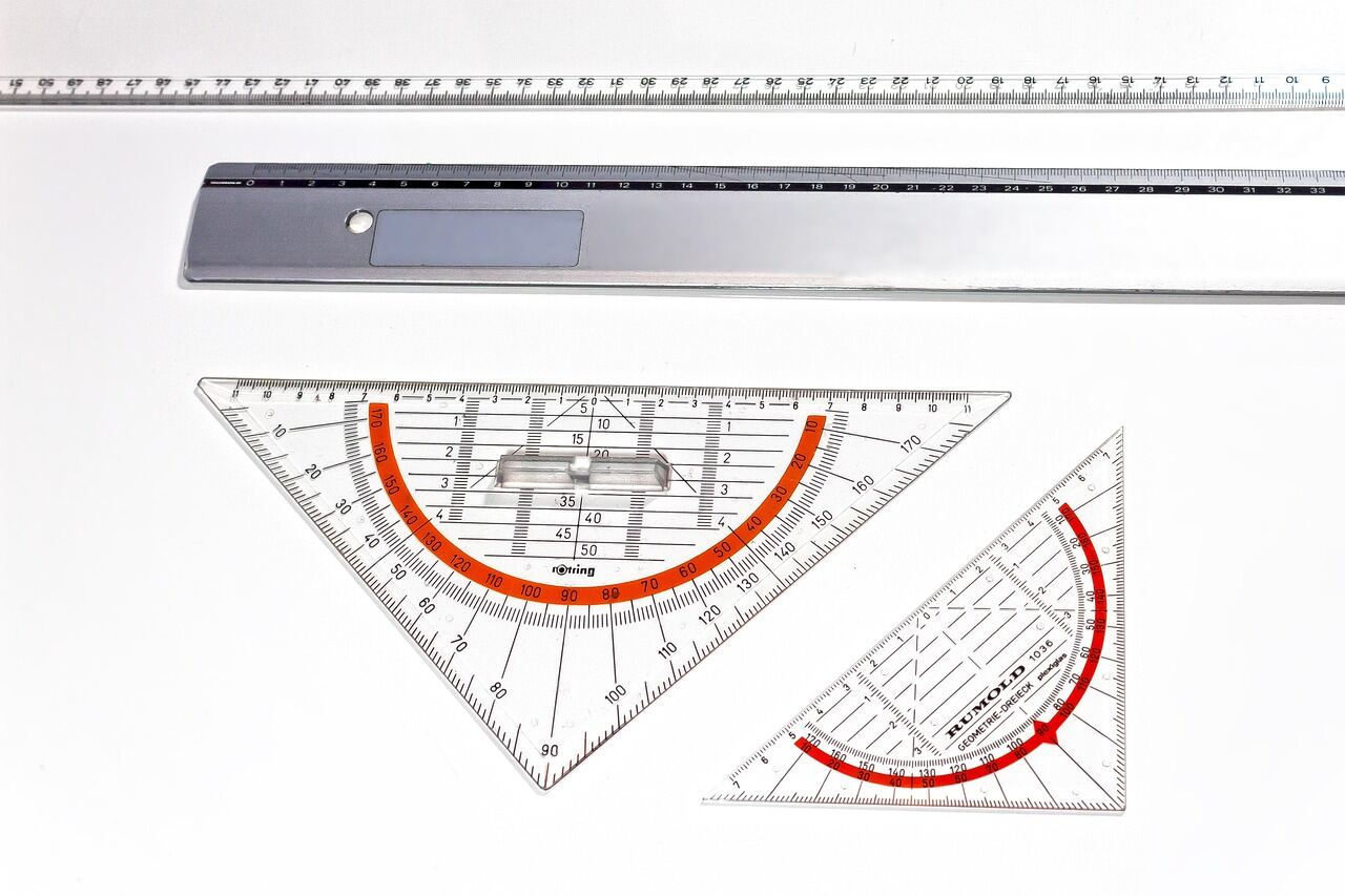 A parallel rule and two metric set squares laid out on a drafting table