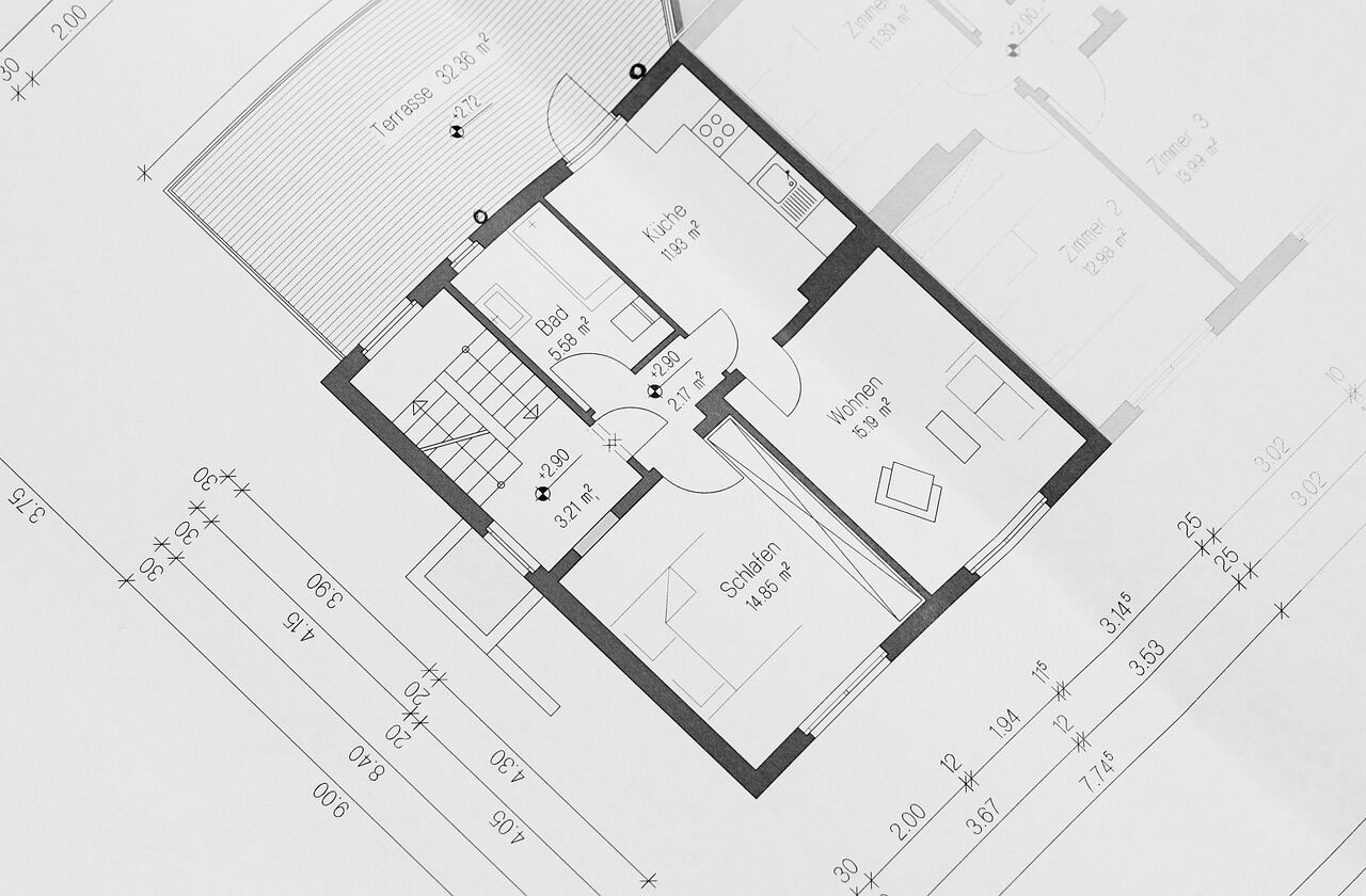 A close-up of an architectural floor plan blueprint, dimension lines and room labels visible