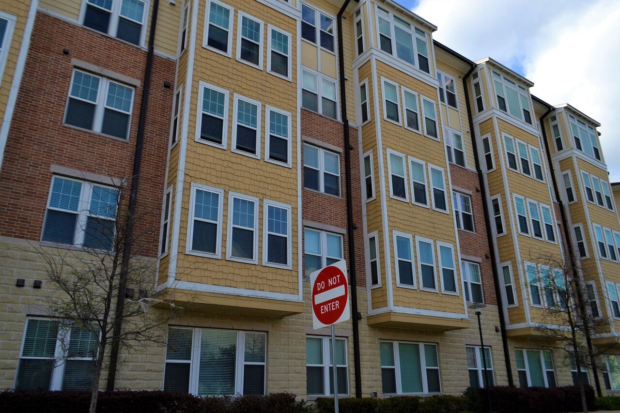 A low-rise multi-unit residential infill building with brick and siding cladding