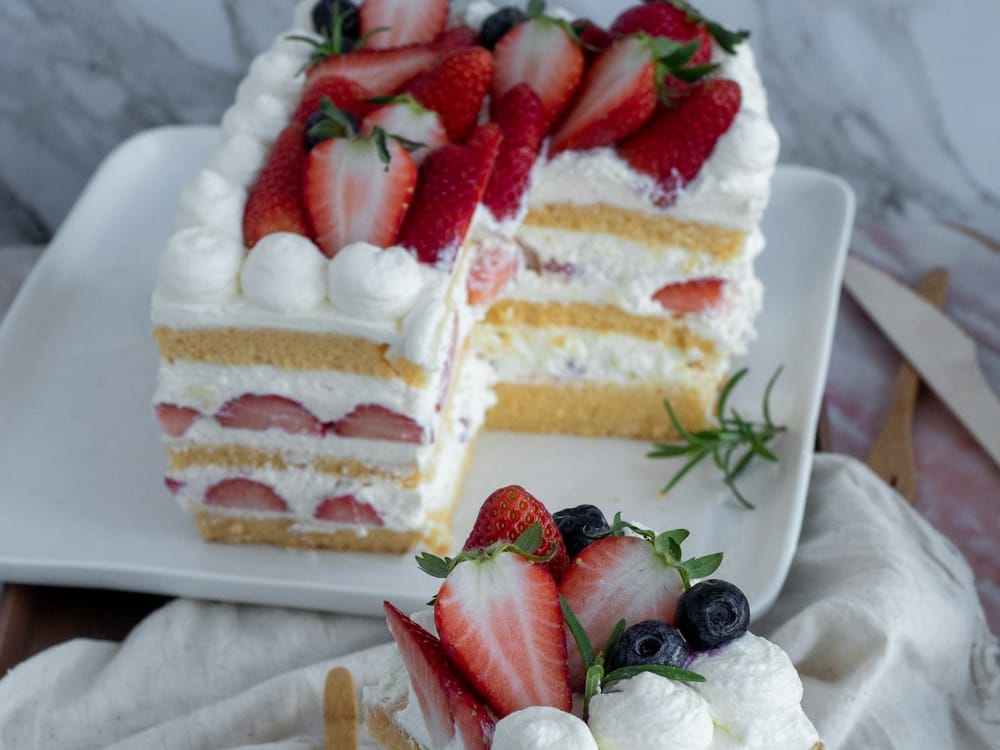 Strawberry layer cake with mascarpone cream and fresh berries on a cake stand