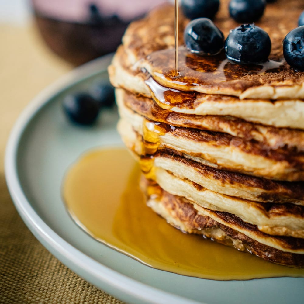 Lemon ricotta pancakes with blueberries on a bright ceramic plate