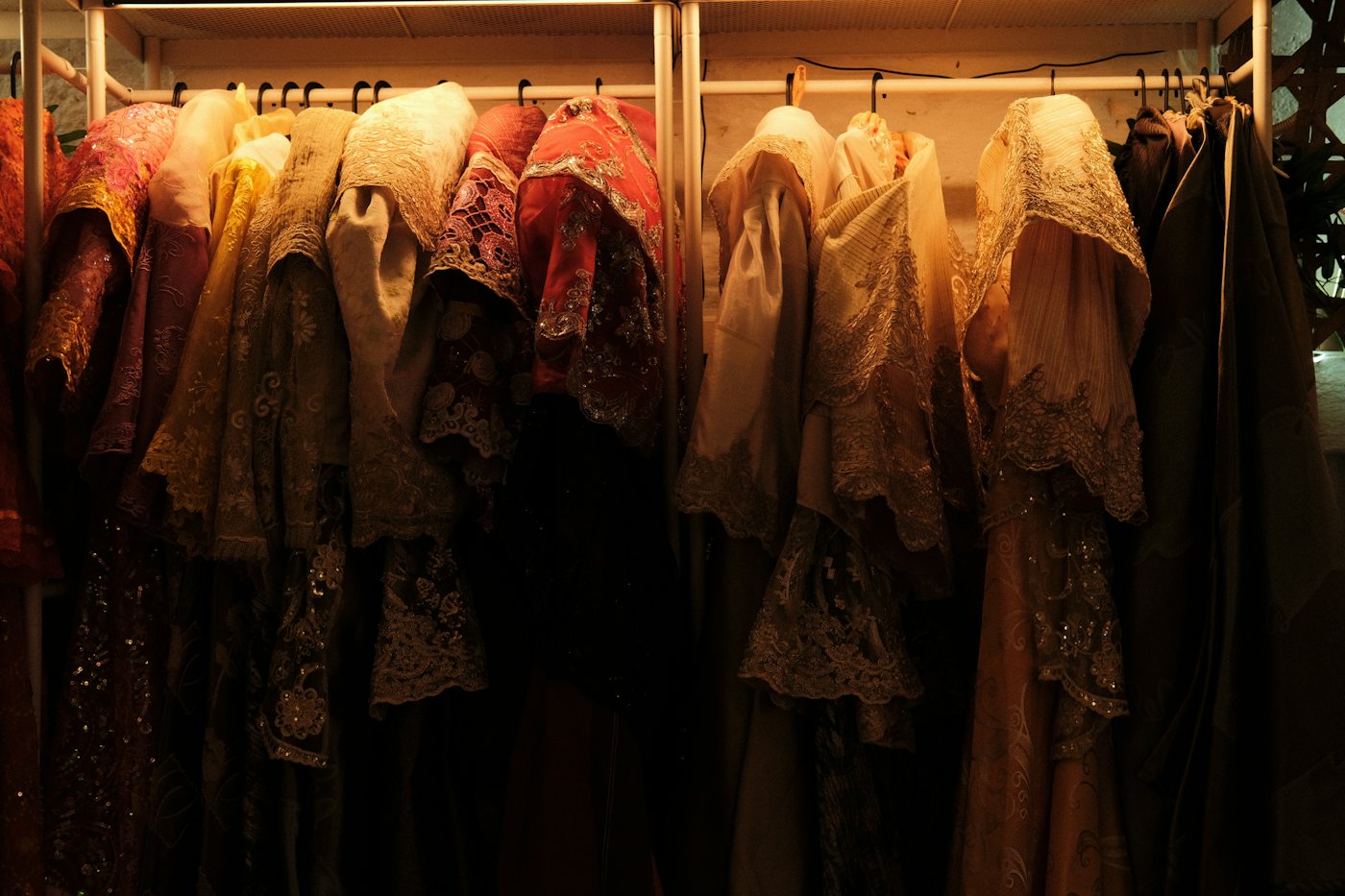 Ornate, embroidered costumes hanging in a row on a wardrobe rack