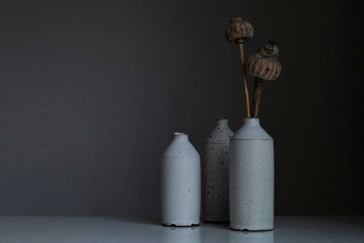 Kūso ceramics packaging — kraft paper wrapping around stoneware bowl on concrete surface