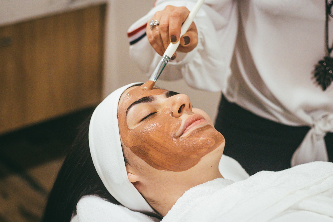 Esthetician performing a professional facial treatment in a clean modern studio