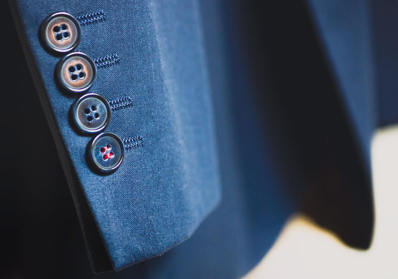 Close-up of horn buttons on a structured blazer sleeve