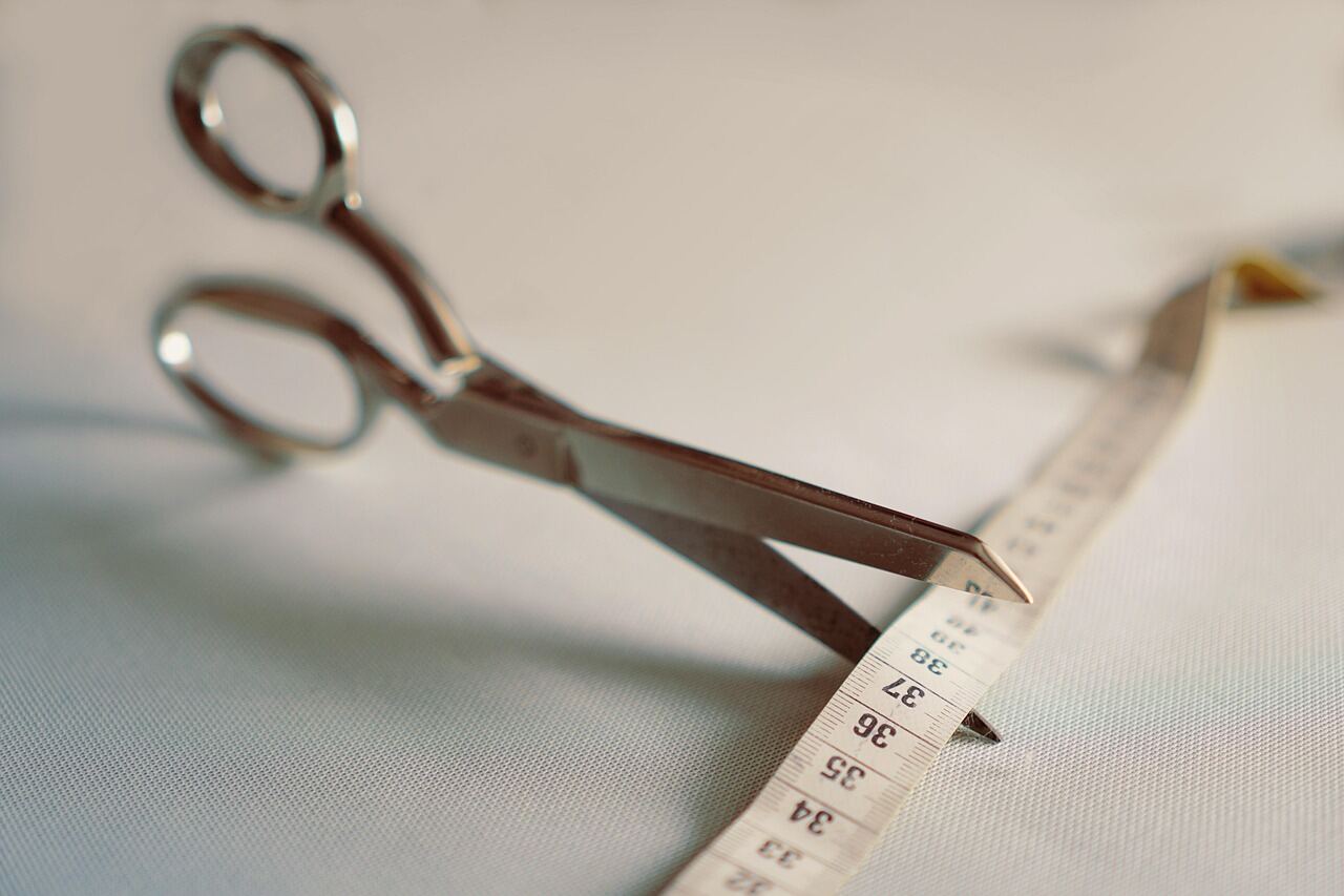 Fabric shears and a tape measure laid on a cutting table