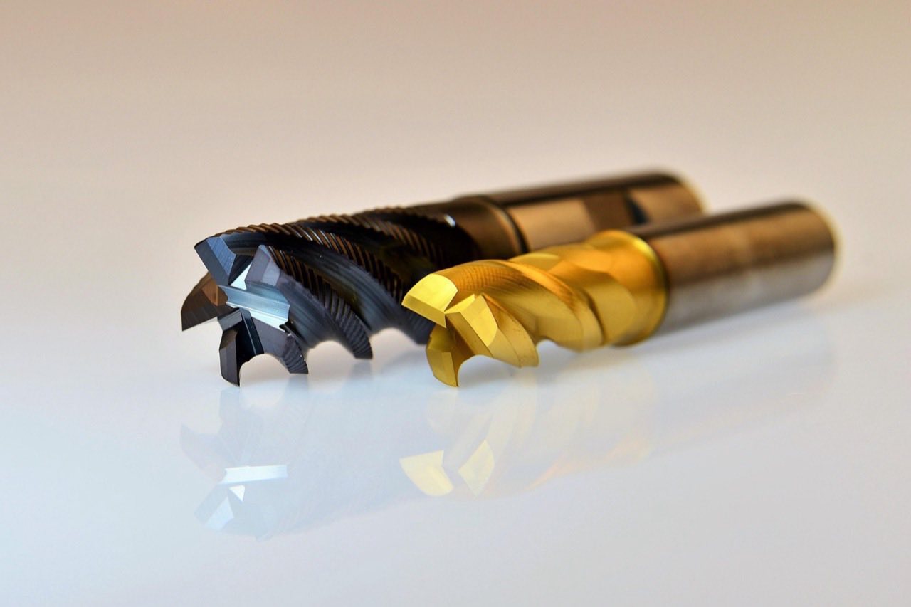 Macro detail of two coated carbide end-mill cutters used for machining steel tooling