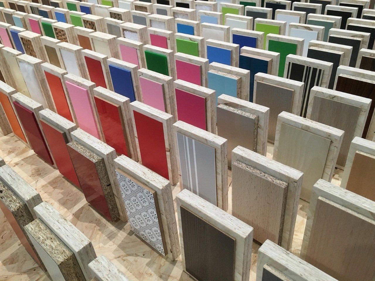 Rows of coloured and textured material sample swatches standing upright in a CMF library