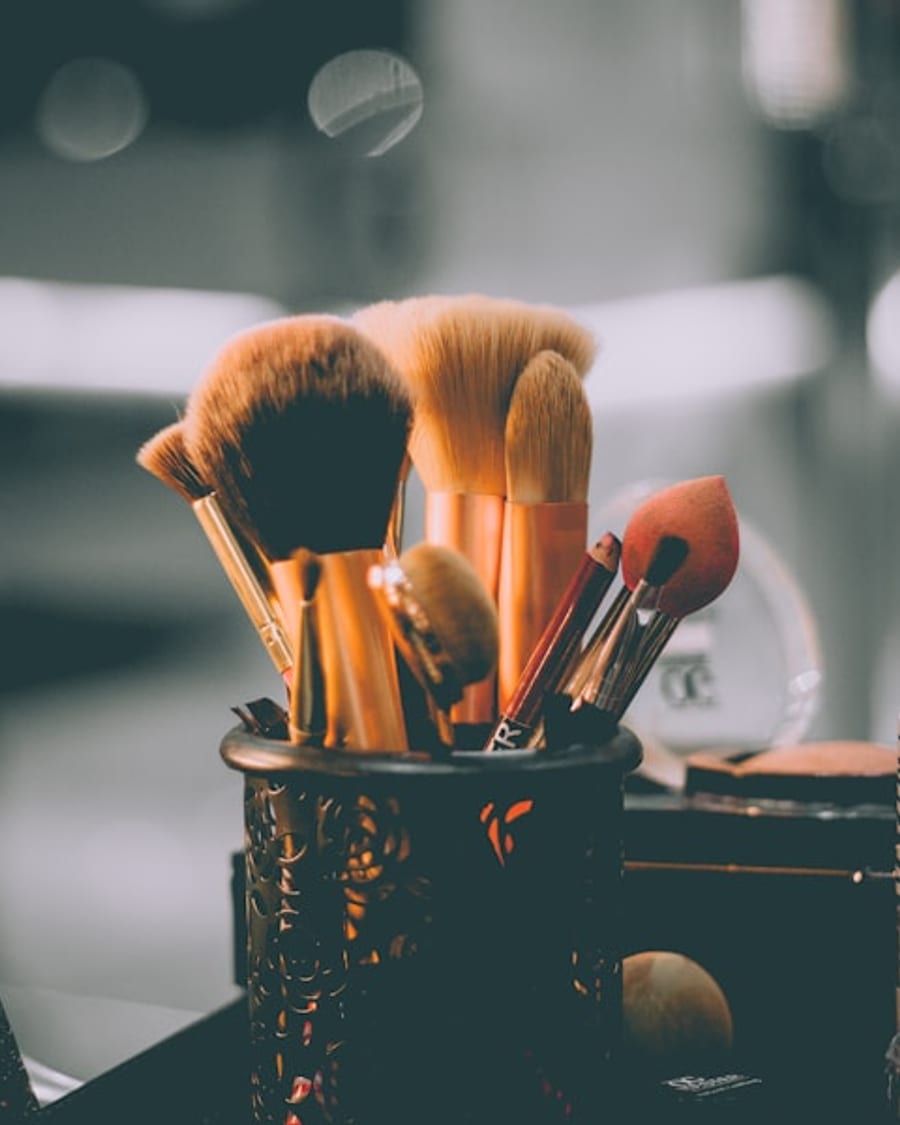 Camille Voss, freelance makeup artist, in her studio reviewing a look with a client