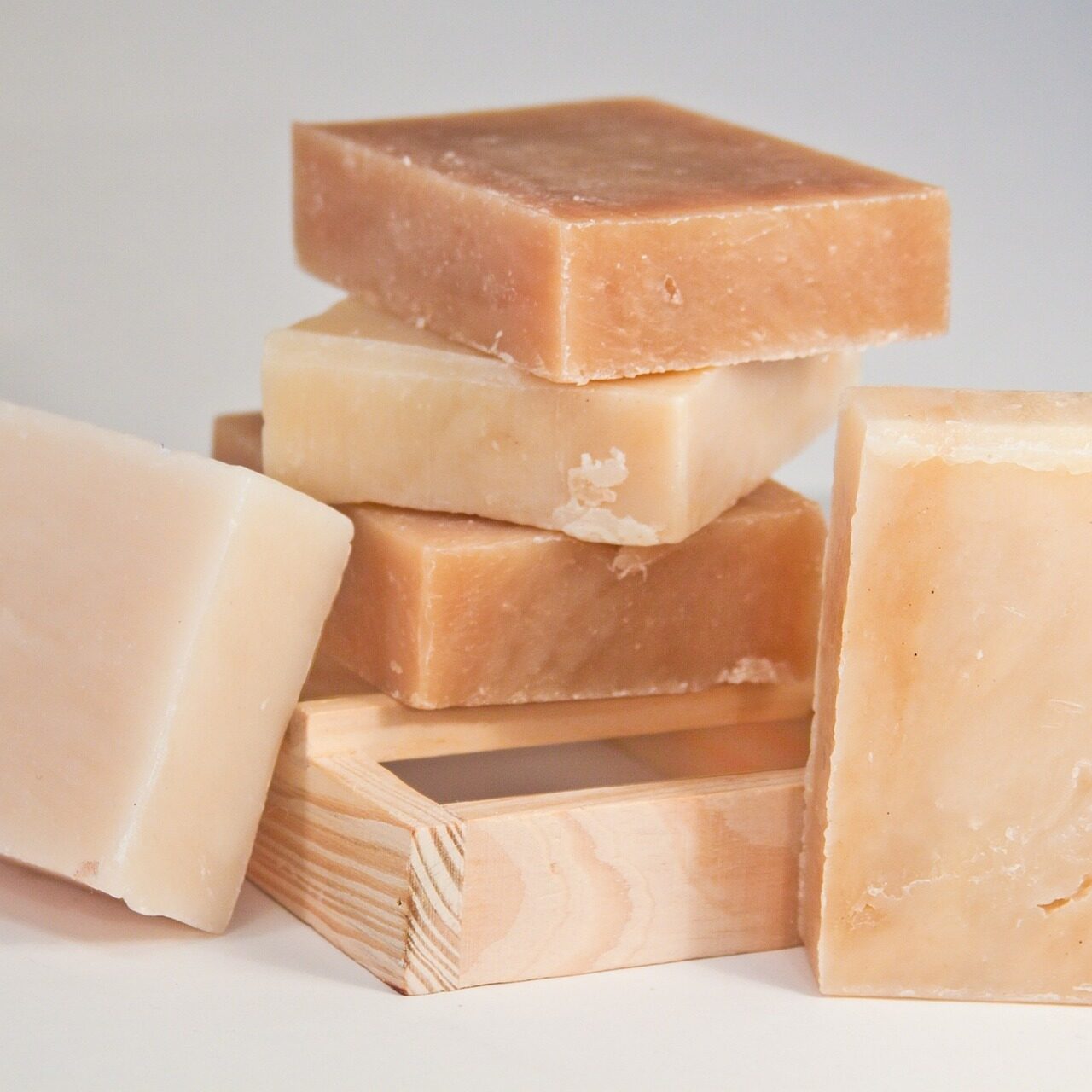 A stack of pale handmade soap bars arranged on a white surface