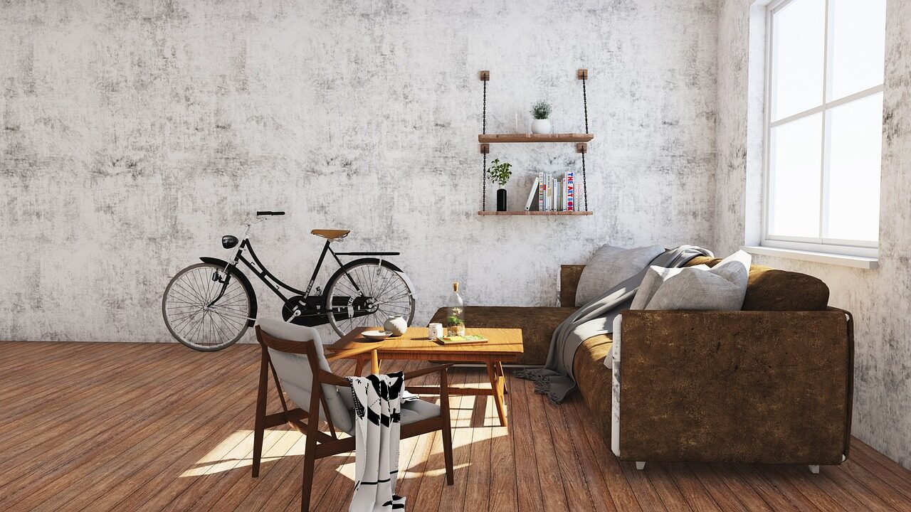 A living room with an exposed concrete wall, leather sofa, wooden floor and a bicycle