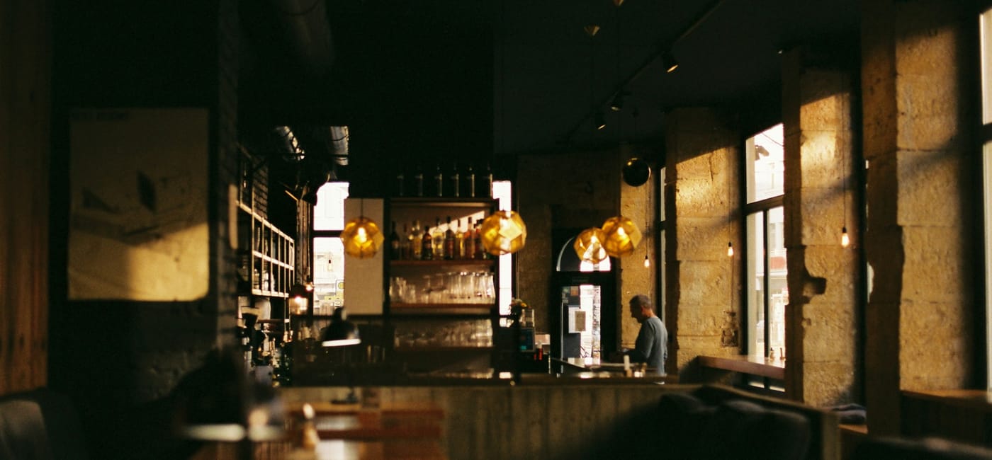 Interior of Ember & Bone — candlelit tables, dark leather, warm brass fixtures