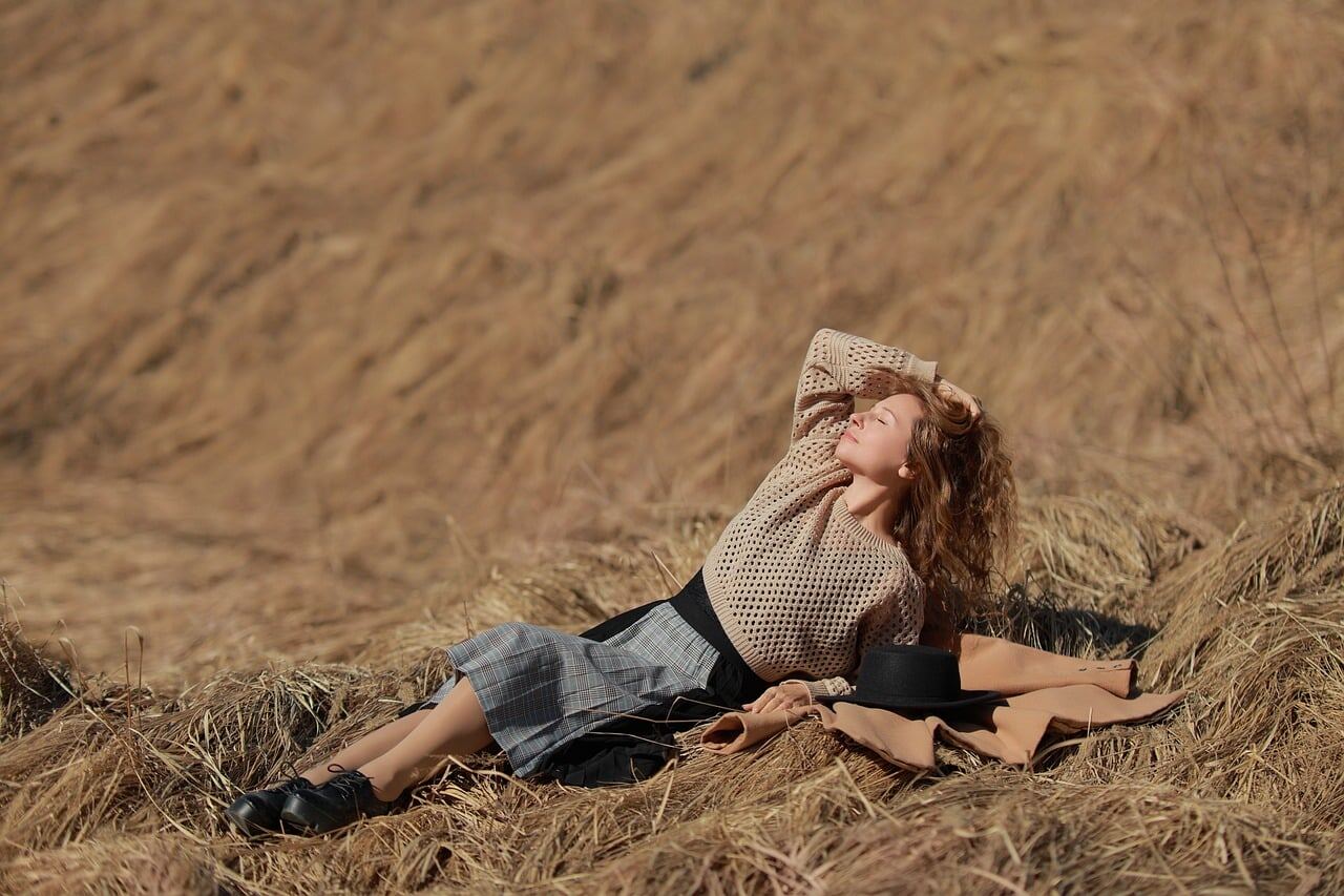 A woman in a beige field coat and hat photographed outdoors for an editorial feature