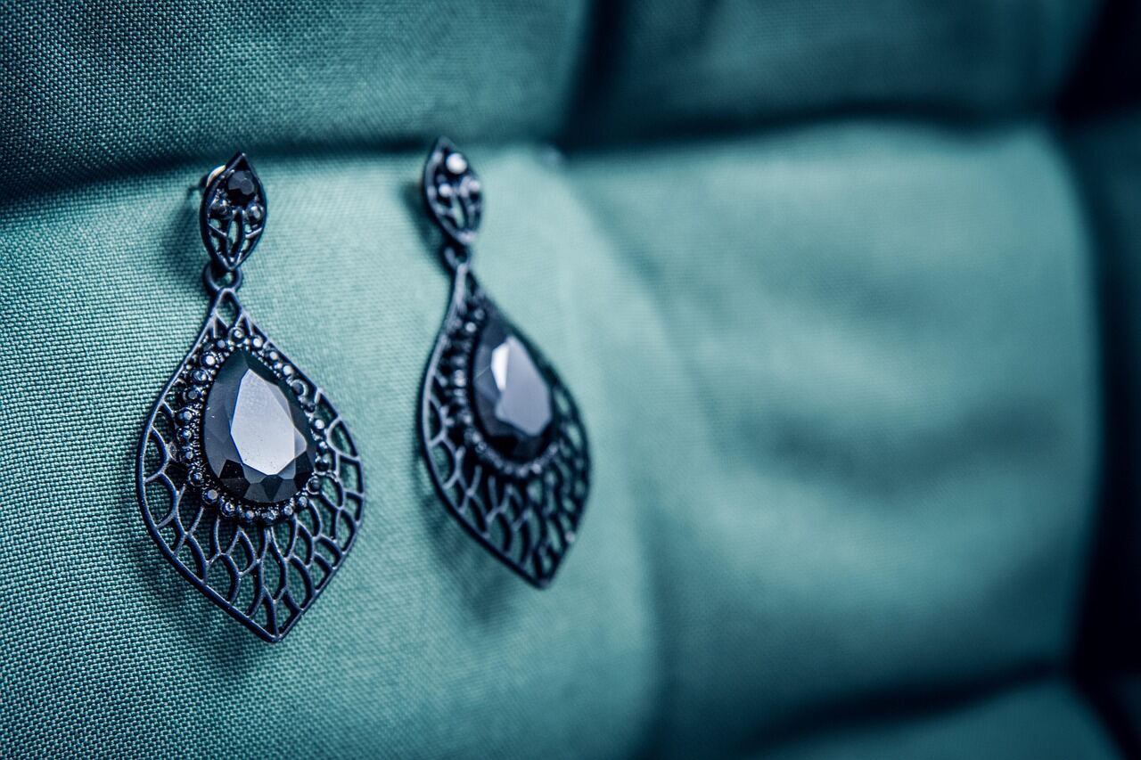 Gold and silver earrings and jewellery arranged as a flat lay for an accessories story