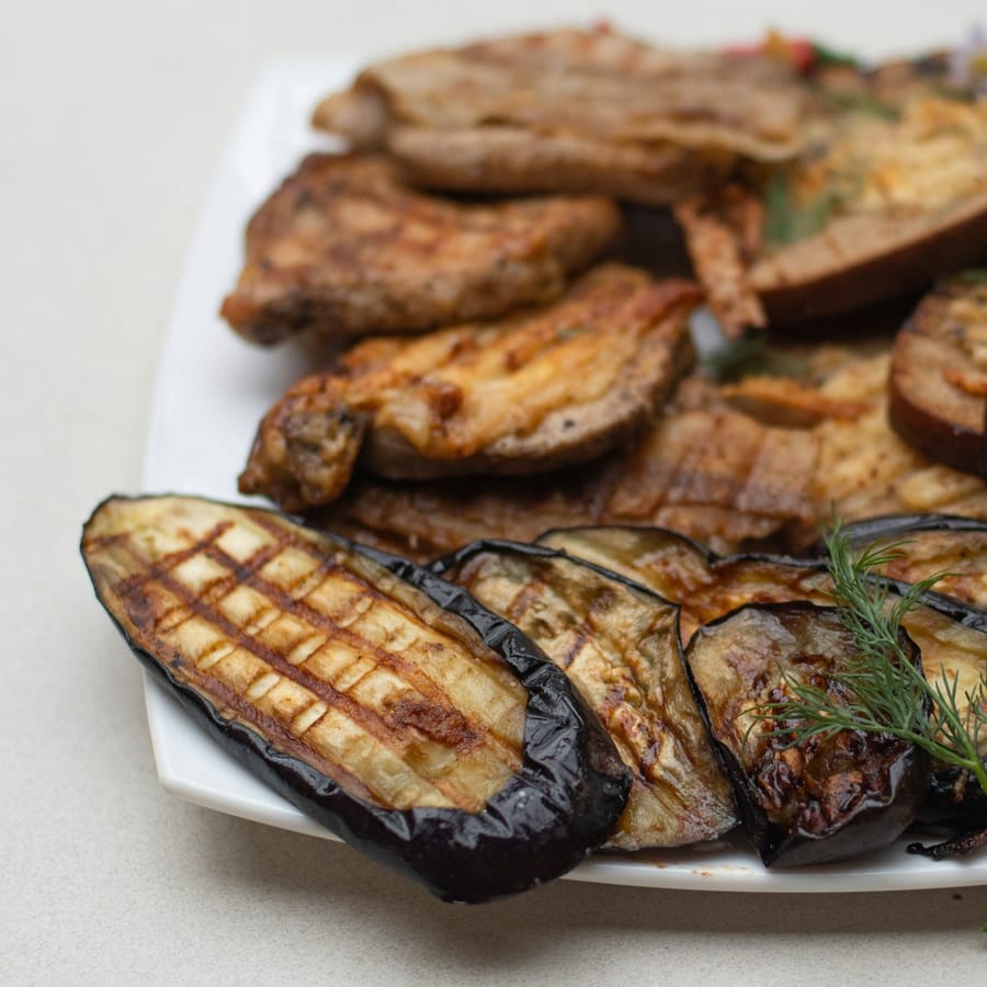Miso-glazed whole aubergine with sesame and shiso on a stone platter