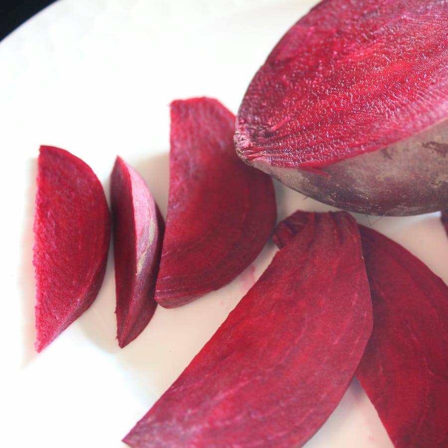 Roasted beet carpaccio with cashew ricotta on a dark ceramic plate