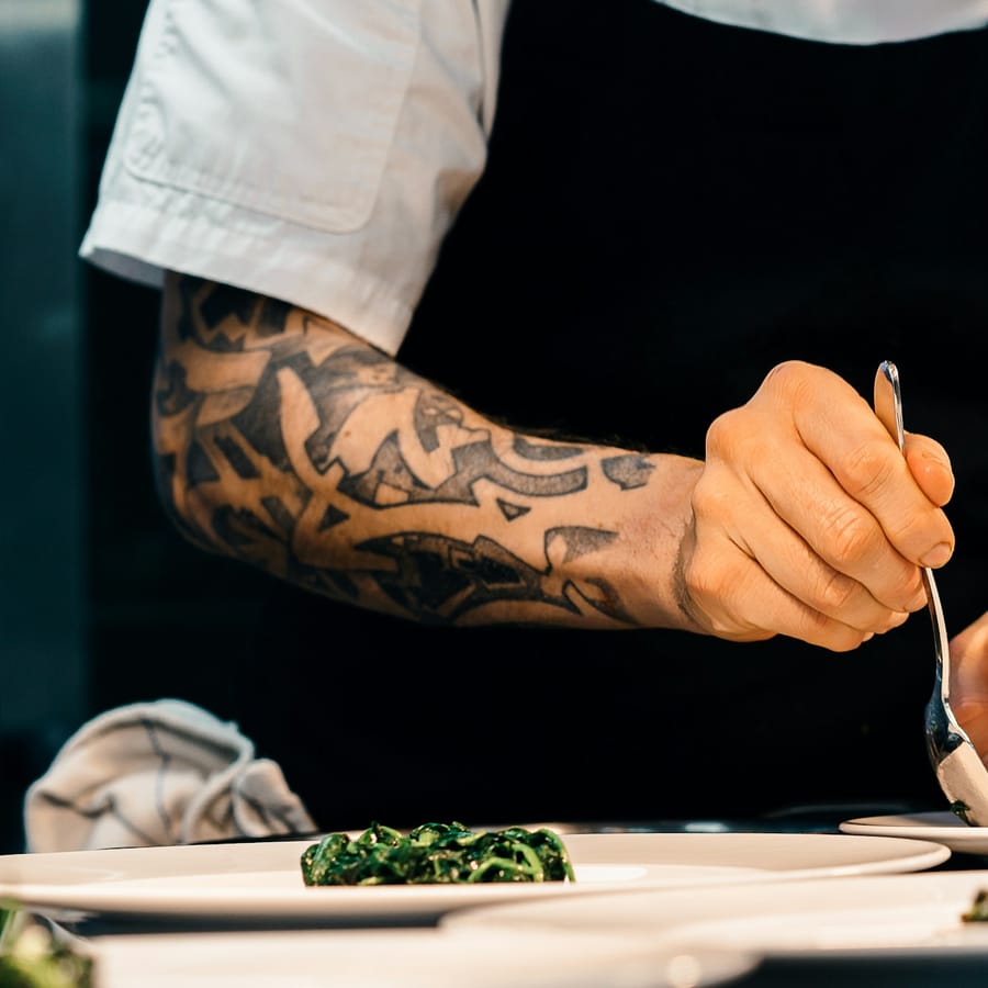 Chef plating a dish in the open kitchen