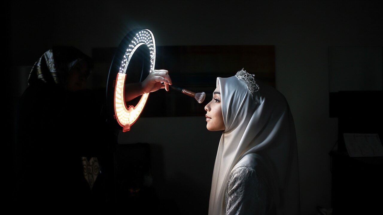 A bride in profile in a darkened room, lit by a ring of sparkler light