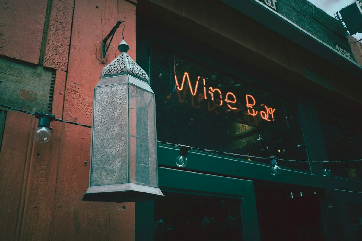 Exterior of Maison Velours at dusk — warm window glow, lit signage, on a quiet Grove Street corner