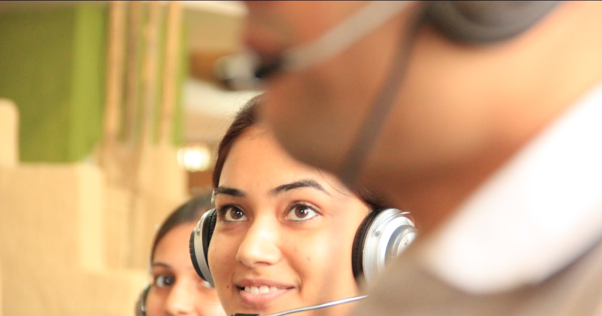Woman in black headphones holding black and silver headphones