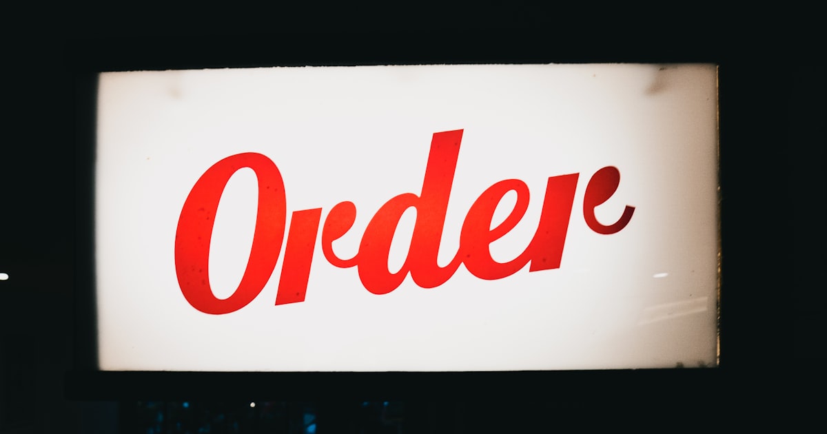 A red order sign hanging from the side of a building