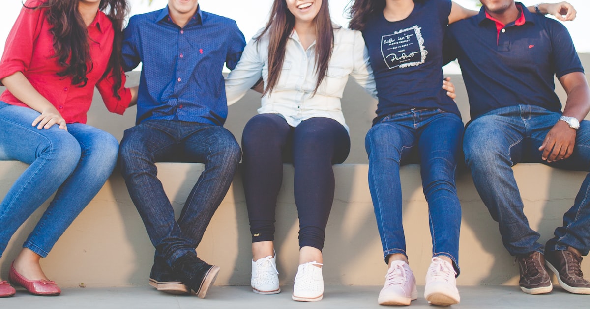 A group of people sitting on a bench near trees