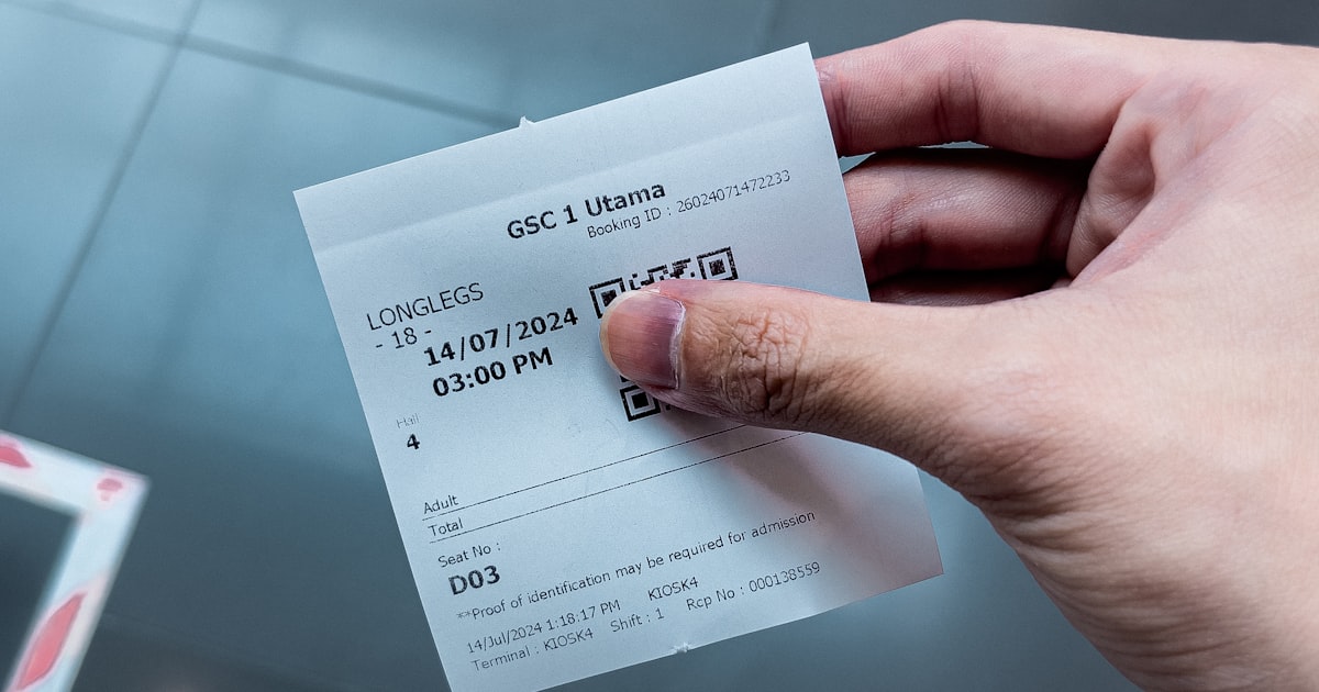 A person holding a paper ticket