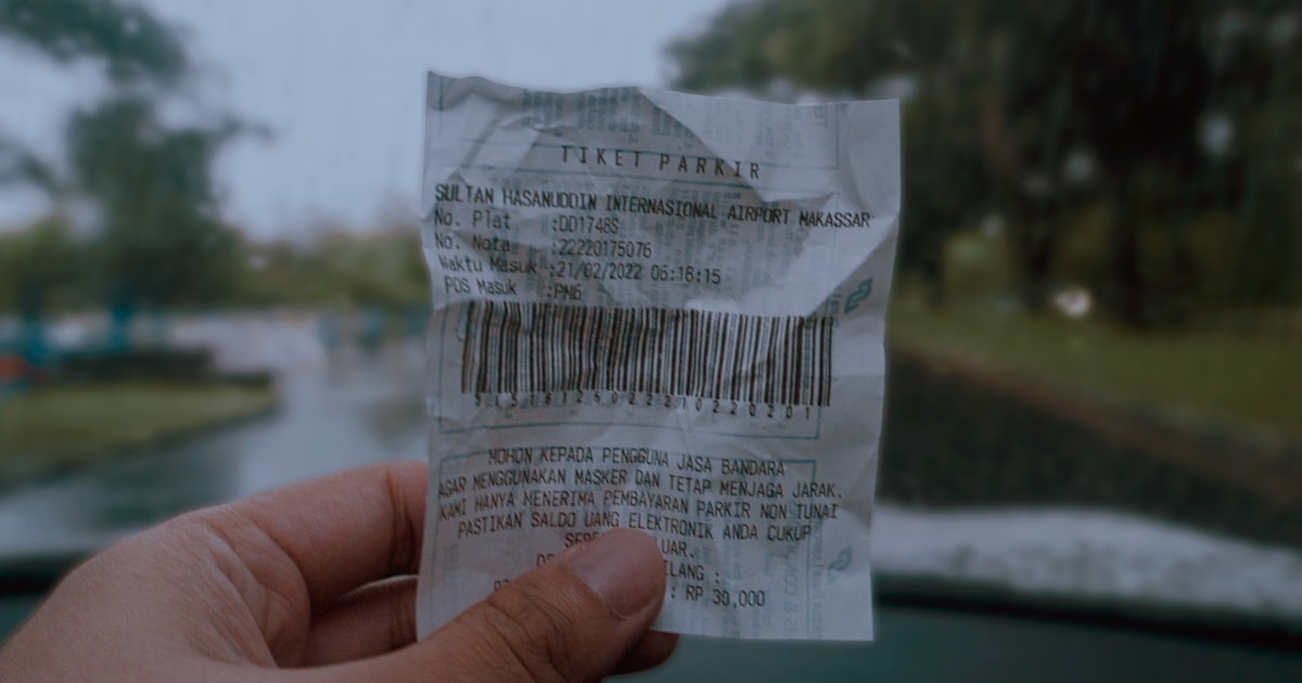 A hand holding a paper with a bar code